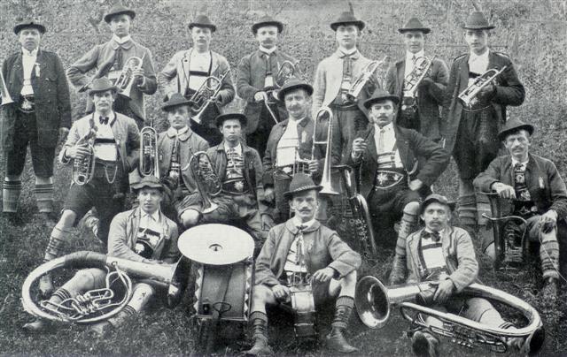 Orchester mit 16 Personen in bayrischer Tracht auf einem Feld